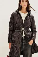 Campera puffer larga de color negro con diseño acolchado en forma de rombos. Cuenta con capucha, cierre frontal, bolsillos con cierre y un cinturón elástico con hebilla metálica en la cintura.