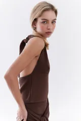 Top bordó de punto con lurex, escote en V profundo estilo halter y diseño sin mangas.