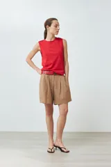 Musculosa de algodón color rojo, con cuello redondo, corte sin mangas y detalle de botones decorativos en los hombros.
