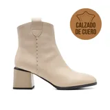 Bota corta color beige de cuero, con caña baja, cierre lateral y taco cuadrado.