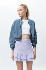 Minifalda color lila con textura tramada y volados en el ruedo. Posee cintura elástica.