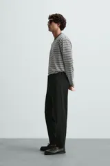 Pantalón chino de corte slim fit, confeccionado en tejido elástico. Presenta bolsillos frontales, bolsillos traseros de vivo con botón y cierre frontal con cremallera y botón.