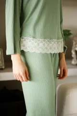 Pijama gris con textura acanalada, compuesto por una remera de manga larga con detalle de puntilla blanca en el ruedo y un pantalón recto con elástico en la cintura y detalle de puntilla blanca en los laterales.