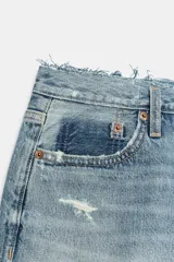 Short de denim tiro medio con trabillas, cinco bolsillos, diseño roto y bajo sin costuras. Cierre frontal con cremallera y botón metálico.