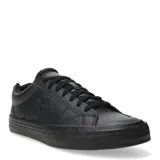 Championes urbanos de cuero sintético negro, de corte bajo, con cordones y suela de goma. Presentan el logo de Converse en el lateral.