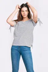 Remera de algodón a rayas horizontales blancas y negras, con cuello redondo y mangas cortas que presentan un detalle de lazo ajustable en los extremos.