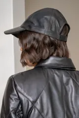 Gorra de cuero color chocolate con bordado frontal en hilo color crema que incluye un símbolo de flor de lis y la inscripción 'EST. 1994'.