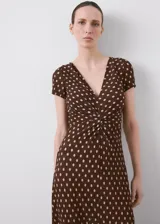 Vestido midi marrón con estampado de lunares claros, escote en V, manga corta y detalle de nudo en el pecho.