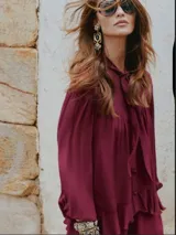 Blusa color borgoña con cuello alto con lazo, mangas 3/4 abullonadas y peplum.