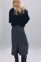 Jersey de punto liso confeccionado en lana 100%, con cuello en pico y manga larga. Presenta acabados en rib en puños y bajo.