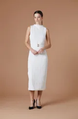 Vestido midi sin mangas, de cuello alto y textura plisada con ondas verticales. Presenta un corte entallado con un cinturón negro integrado que incluye una hebilla metálica dorada con el logo de la marca.