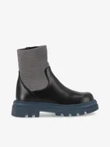 Bota estilo combat boot confeccionada en eco cuero negro con acabado mate y suela de goma azul. Presenta una caña alta de textura elastizada en color gris y cierre lateral.