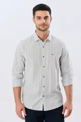 Camisa de manga larga de lino y algodón, con diseño de rayas verticales en tonos celestes y blancos. Presenta cuello camisero, cierre frontal con botones y pequeño bordado al tono en el pecho.