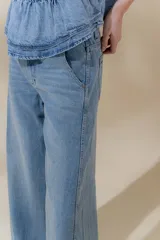 Pantalón de jean de tiro medio y pierna ancha, confeccionado en denim 100% algodón. Diseño con 5 bolsillos y pespuntes a contratono.