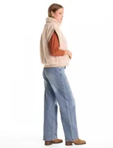 Chaleco de piel sintética en color beige, con cuello alto, cierre frontal metálico y terminaciones en tejido rib en el ruedo y sisas.