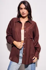 Camisa marrón de tencel y poliéster, corte oversize, manga larga y cierre con botones.