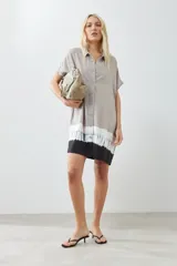 Vestido camisero color beige con detalle de teñido tie dye en blanco y negro en el ruedo.