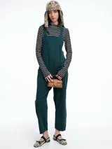 Mono largo de pana color verde oscuro, con breteles finos y silueta relajada de pierna amplia.