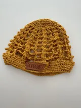Gorro tipo beanie tejido a mano en hilo de algodón, color beige jaspeado, con diseño de malla calada y etiqueta de cuero marrón con el nombre 'Soriame' grabado.