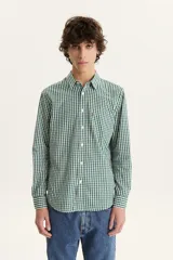 Camisa de manga larga a cuadros verdes y blancos, con cuello clásico, cierre con botones y bolsillo en el pecho.