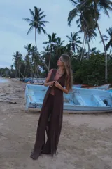 Chaleco largo de tejido de punto color marrón, con escote en V profundo y cierre frontal mediante un pequeño gancho metálico. Presenta un diseño de punto con textura geométrica y aberturas laterales.