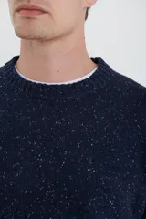 Sweater de escote redondo con manga larga, confeccionado en tejido moteado de textura suave.