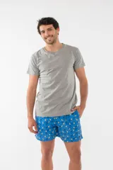 Short de baño azul con estampado de piñas y palmeras, cuenta con cintura elástica, bolsillos laterales y un bolsillo trasero con cierre.