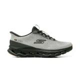 Championes deportivos Skechers Slip-Ins Go Walk Glide Step, color gris con suela negra y detalles en naranja. Diseño sin cordones con parte superior de malla técnica y entresuela geométrica.