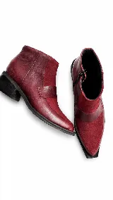 Bota corta de cuero con textura tipo reptil y paneles de gamuza en tono marrón oscuro. Presenta un diseño de punta cuadrada, cierre lateral y un taco cuadrado de madera.