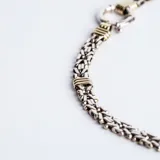Gargantilla de cadena de eslabones tipo bizantino en plata 925, con detalles de apliques en oro y cierre marinero frontal.