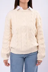Sweater de punto con diseño de trenzas y rombos, color marrón, de cuello redondo y corte holgado.