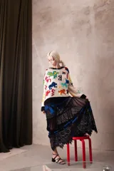 Falda larga de tul negro con diseño evasé, presenta franjas horizontales de encaje y plumeti que aportan textura y movimiento. Cuenta con cintura elástica para un ajuste cómodo.