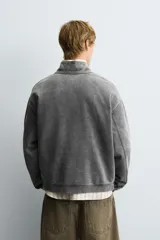 Sudadera de corte boxy fit con cuello subido y cierre frontal de cremallera. Presenta mangas largas, acabado efecto lavado y puños y ruedo en rib.