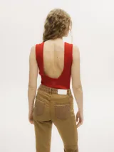 Body de lurex color negro, con diseño acanalado, cuello redondo a la base, corte cavado y espalda abierta con tiras cruzadas.