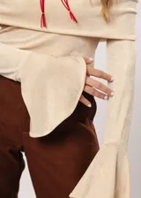 Blusa beige con hombros descubiertos, mangas largas acampanadas y confeccionada en tela stretch con lurex.