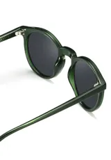 Lentes de sol redondos con montura gris translúcido y lentes verdes. Fabricados con acetato biodegradable y lentes de PMMA reciclado.