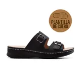 Sandalias negras con plantilla de cuero, dos tiras anchas con hebillas metálicas y suela con plataforma baja.