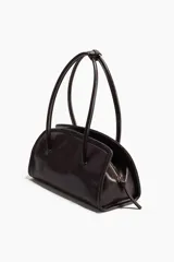 Cartera de hombro rectangular con acabado brillante, cierre superior y asas largas unidas por una trabilla con hebilla metálica.
