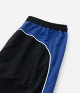 Pantalón deportivo de corte recto confeccionado en microfibra de poliamida, color negro con paneles laterales en color violeta y detalles en blanco. Cuenta con cintura elástica con cordón ajustable.