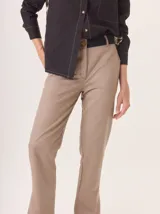 Pantalon de corte cigarrillo con pierna angosta, confeccionado en una mezcla de algodon y tencel. Presenta un diseño minimalista con detalles de costura en contraste y una pequeña abertura en el ruedo.