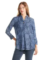 Blusa de lyocell con estampado floral en tonos azules, cuello con solapa, escote en V con botón frontal, mangas tres cuartos con puño ancho y ruedo curvo.