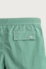 Short de baño verde con cintura elástica ajustable con cordón, bolsillos laterales y pespuntes en contraste.