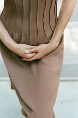 Vestido midi marrón de punto con escote en V y tirantes finos, con detalle de costuras verticales en el talle y falda acampanada.