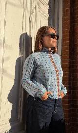 Cardigan reversible de punto con estampado de rombos pequeños, cuello alto y cierre frontal completo con botones. Presenta detalles de ribetes en color contrastante en cuello, puños y cartera de botones.
