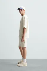 Sudadera de manga corta color marrón oscuro, con cuello redondo y bajo acabado en rib. Presenta un corte relajado y holgado (boxy fit).