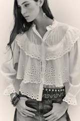 Camisa de algodón con diseño de encaje bordado, cuello mao, cierre frontal de botones y mangas largas con puños con volados.