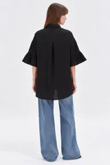 Camisa de algodón negra con cuello camisero, cierre frontal con botones y mangas 3/4 terminadas en volados.