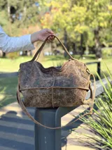 Bolso de mano y hombro confeccionado en cuero con acabado texturizado efecto desgastado. Cuenta con doble correa, cierre superior y diseño espacioso.