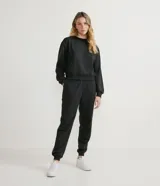 Buzo negro de algodón, de corte holgado, cuello redondo y mangas largas.