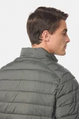 Campera de abrigo gris oscuro, capitoneada, con cuello alto y capucha desmontable. Cierre frontal con cremallera y bolsillos laterales con cierre. Logo bordado en el pecho.
